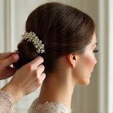 Coiffeuse réalisant un chignon de mariée sophistiqué